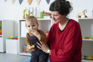 medium shot teacher holding little kid 1024x683 1